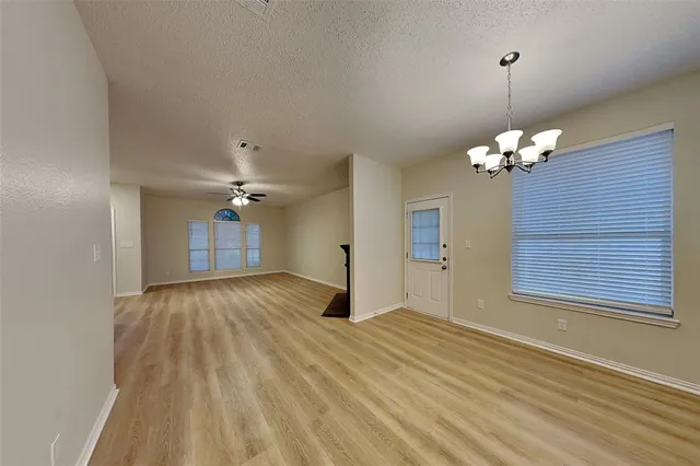 a very nice looking room with a chandelier fan and windows