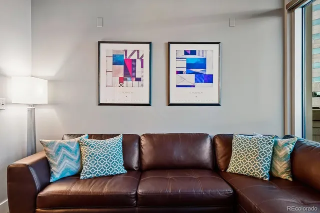 a living room with furniture a flat screen tv and a floor to ceiling window