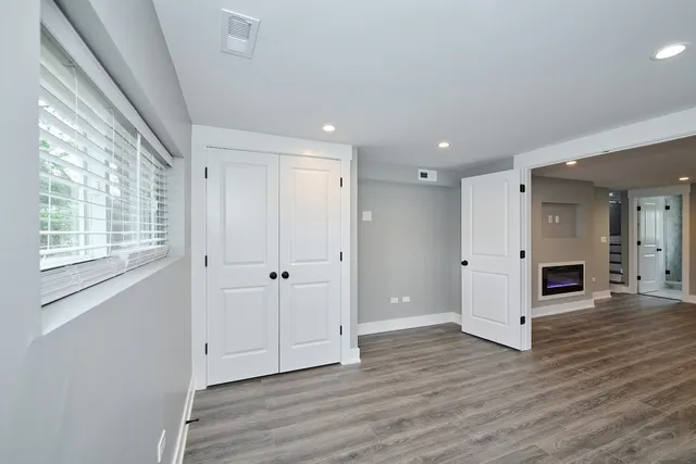 a view of empty room with wooden floor and fireplace