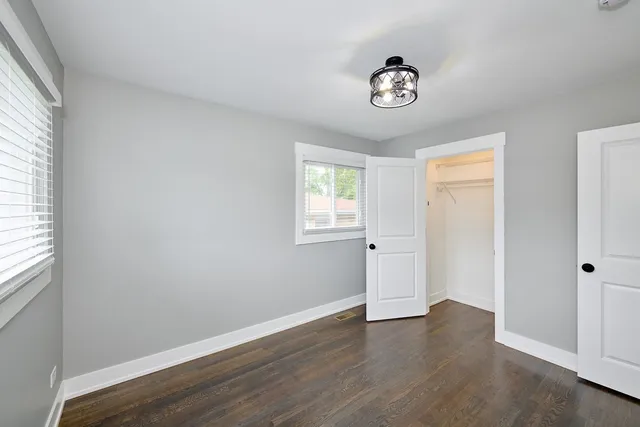 a view of empty room with wooden floor and window
