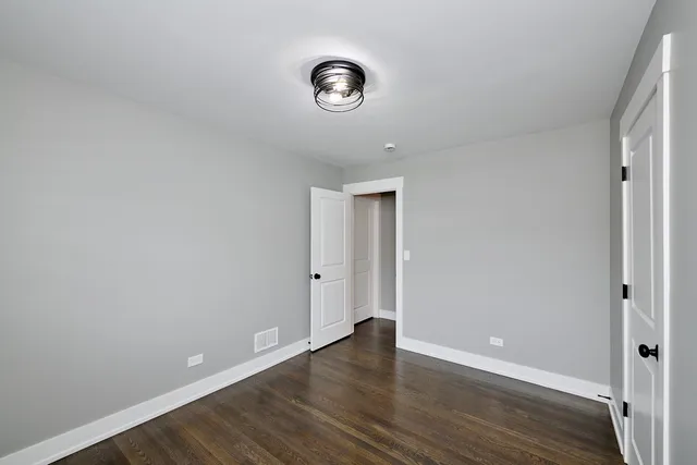 an empty room with wooden floor and a window
