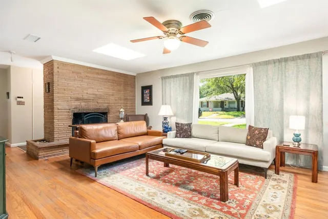 a living room with furniture a large window and a fireplace