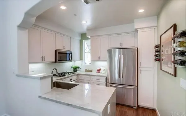 a kitchen with stainless steel appliances granite countertop a sink a stove and microwave