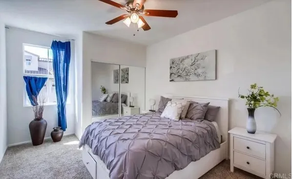 a bedroom with a large bed and a chandelier