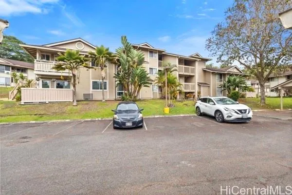 a view of a building with cars parked in front of house