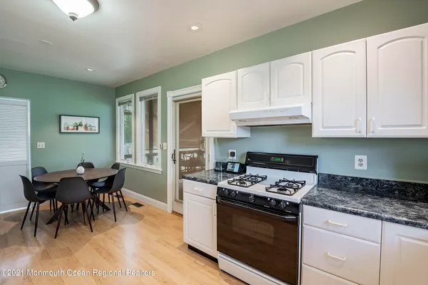 a kitchen with granite countertop cabinets stainless steel appliances and a dining table