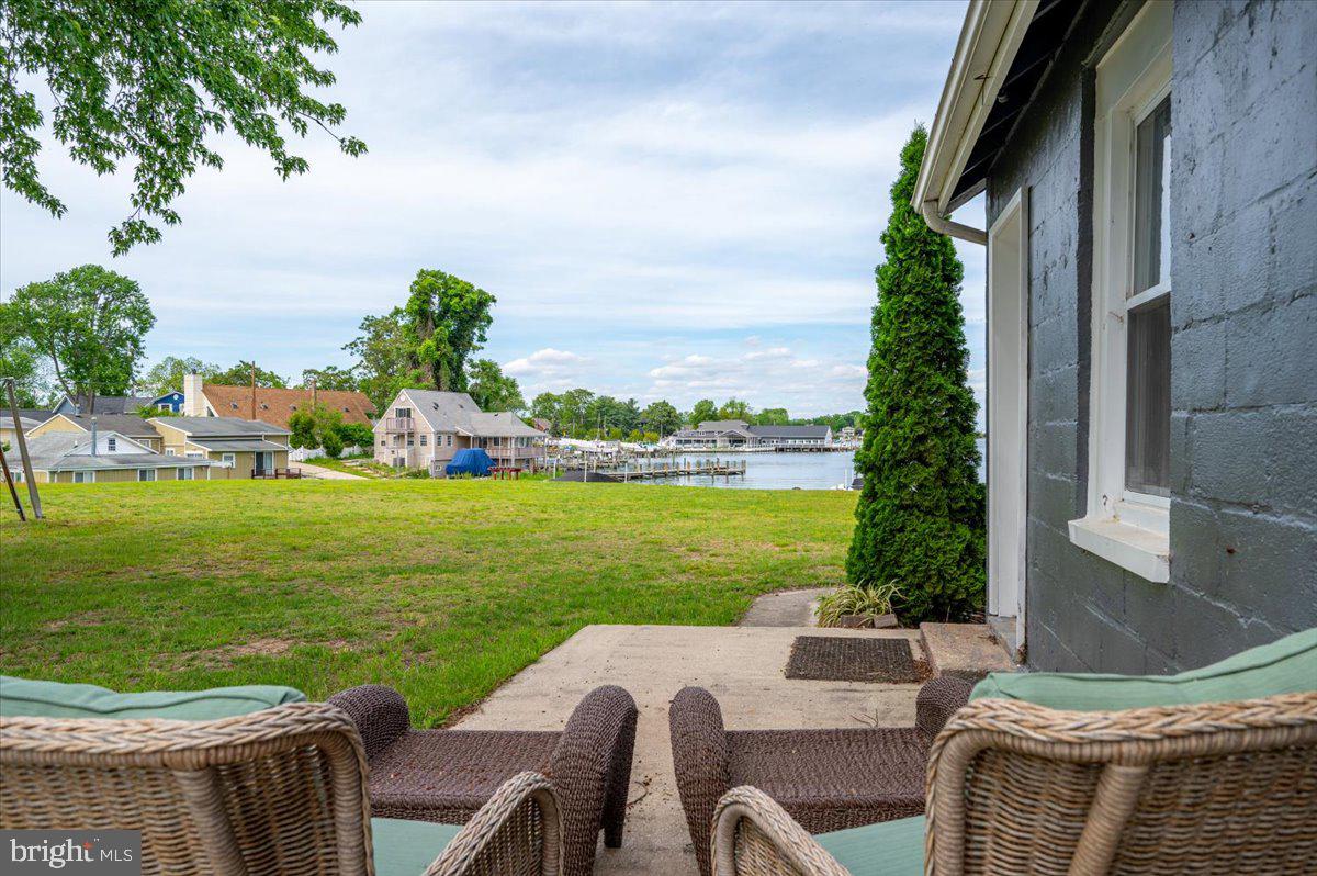 1312 Tuggies Road Pasadena, MD 21122 - Photo 23 of 75 a view of a patio with lawn chairs floor to ceiling window and yard