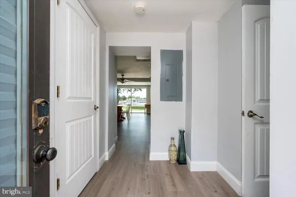 a view of a hallway with wooden floor and closet area