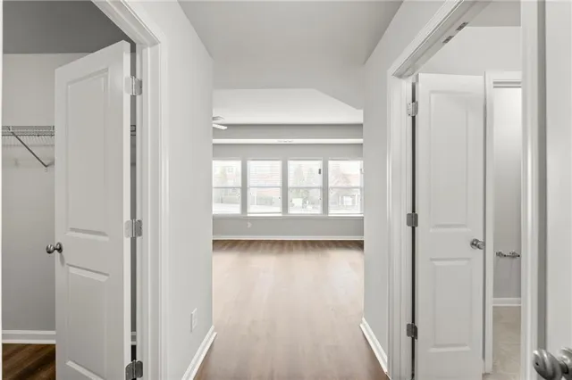 a view of empty room with wooden floor and fan