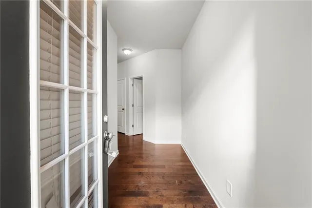a view of a hallway with wooden floor and staircase