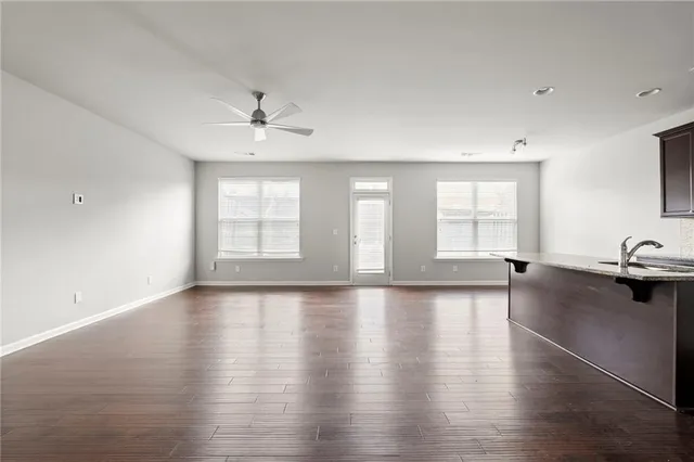a view of an empty room with a window and wooden floor