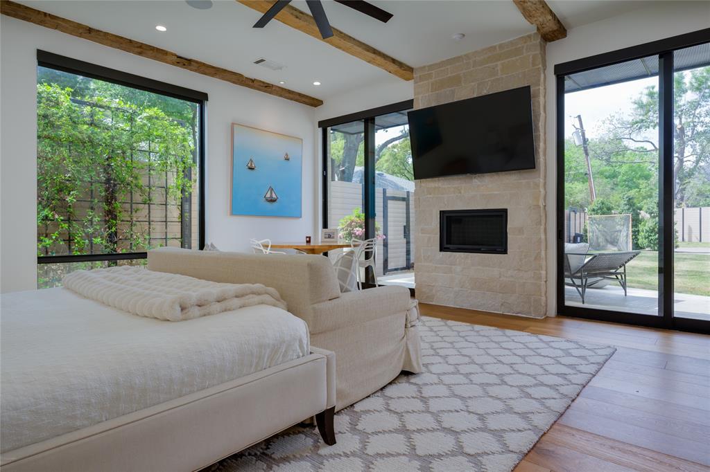 5736 Stonegate Road Dallas, TX 75209 - Photo 16 of 29 Expansive windows, wood-finish flooring, stone fireplace, exposed beam ceiling, and recessed lighting