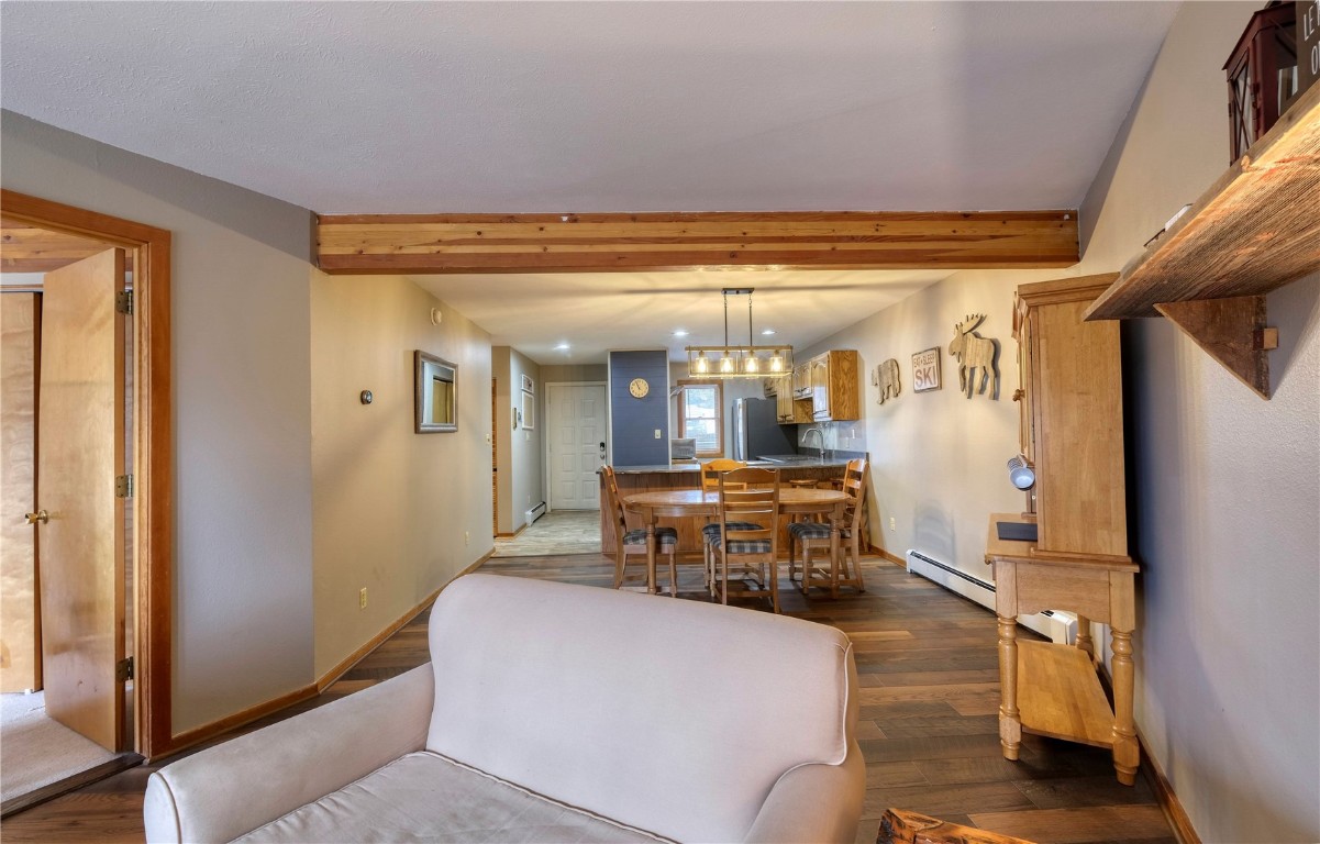 94300 Ryan Gulch Road, Unit 94302 Silverthorne, CO 80498 - Photo 12 of 33 a dining room with furniture and a chandelier