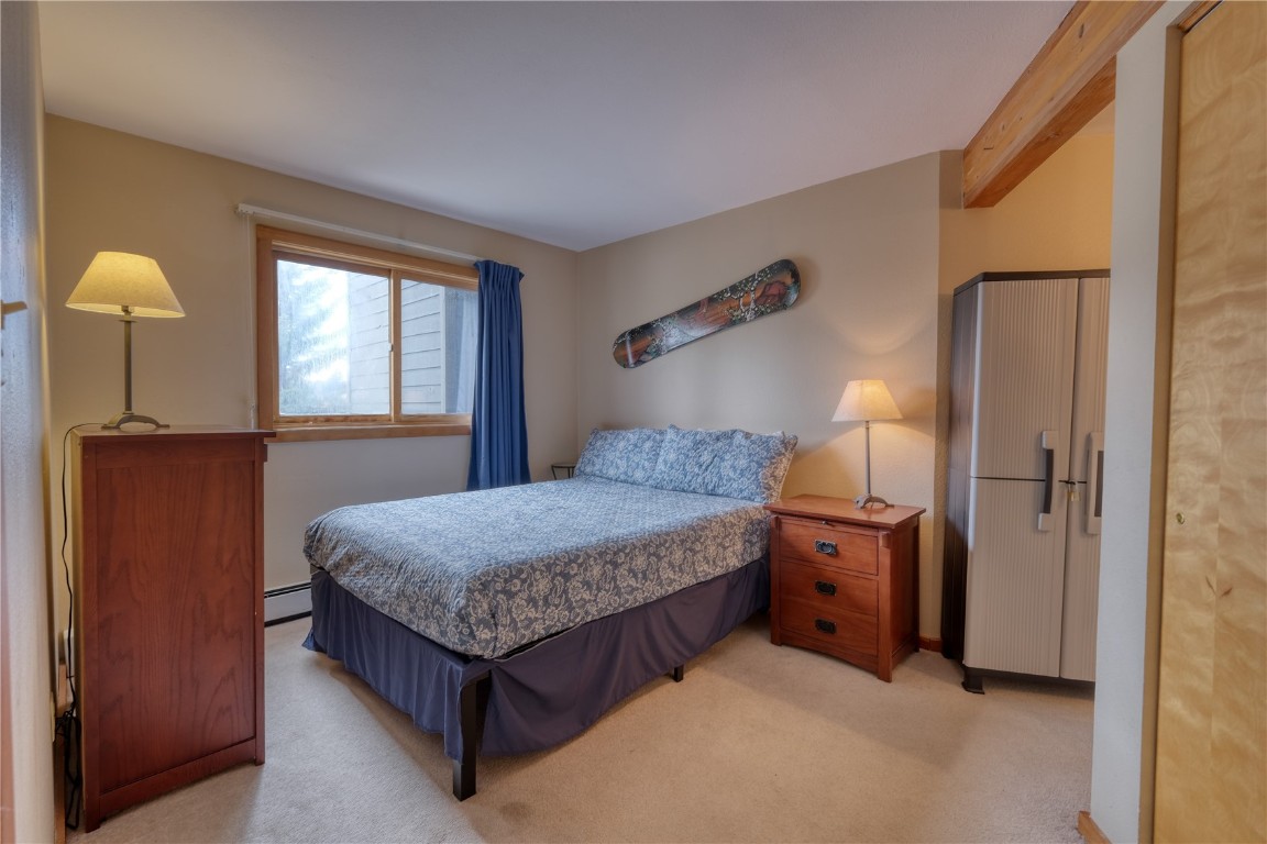 94300 Ryan Gulch Road, Unit 94302 Silverthorne, CO 80498 - Photo 13 of 33 a bedroom with a bed and window