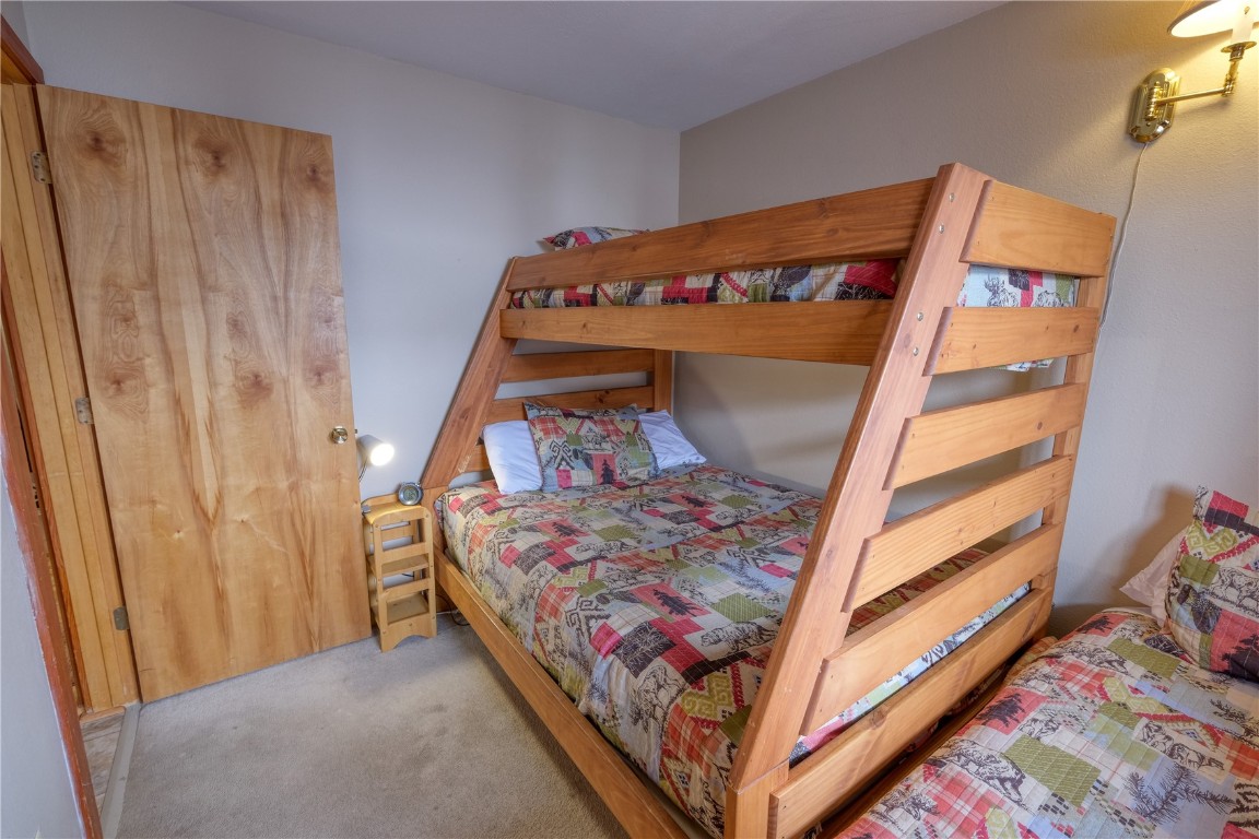 94300 Ryan Gulch Road, Unit 94302 Silverthorne, CO 80498 - Photo 18 of 33 a bed sitting in a bedroom next to a window