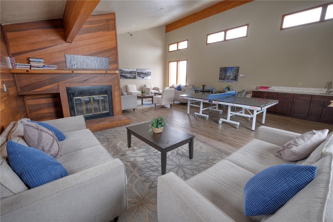 94300 Ryan Gulch Road, Unit 94302 Silverthorne, CO 80498 - Photo 30 of 33 a living room with furniture a fireplace and a table