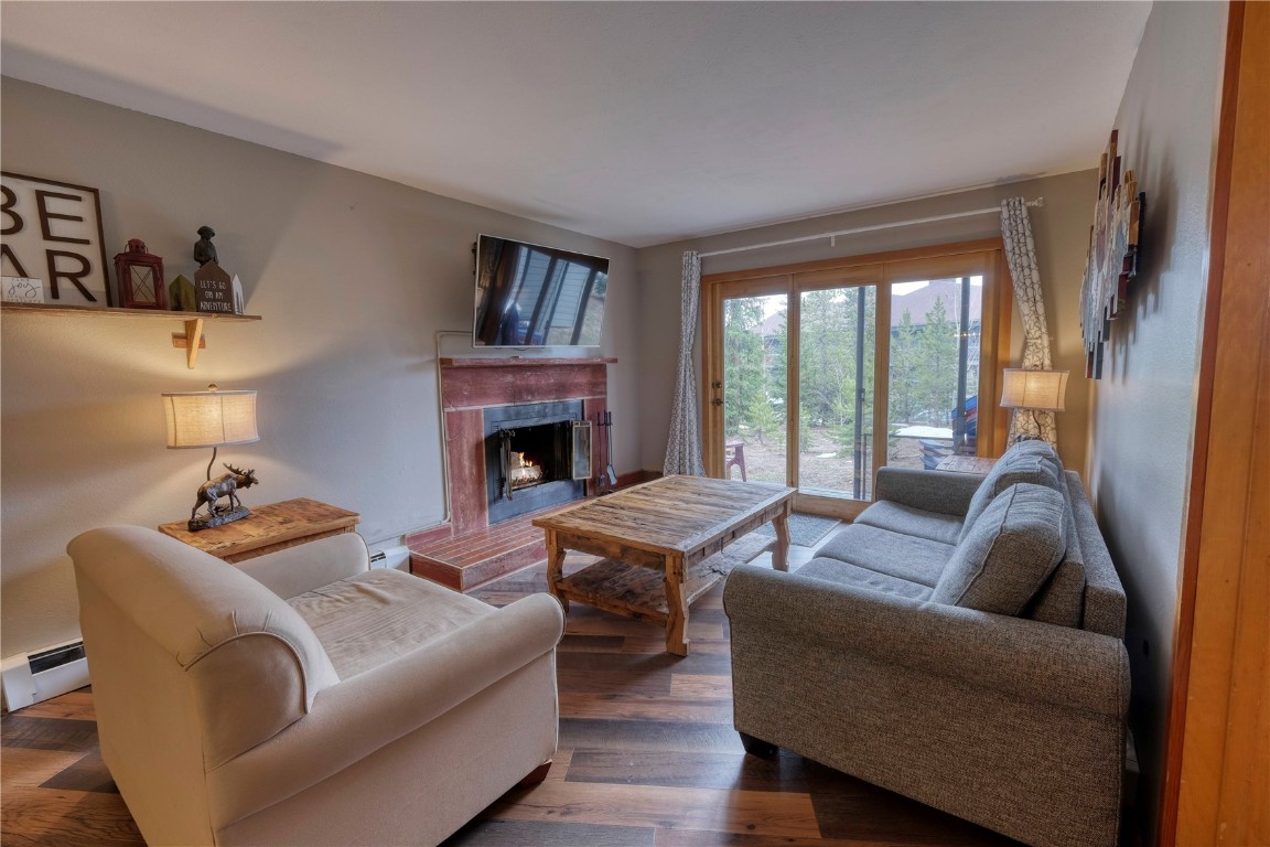 94300 Ryan Gulch Road, Unit 94302 Silverthorne, CO 80498 - Photo 8 of 33 a living room with furniture large window and a fireplace