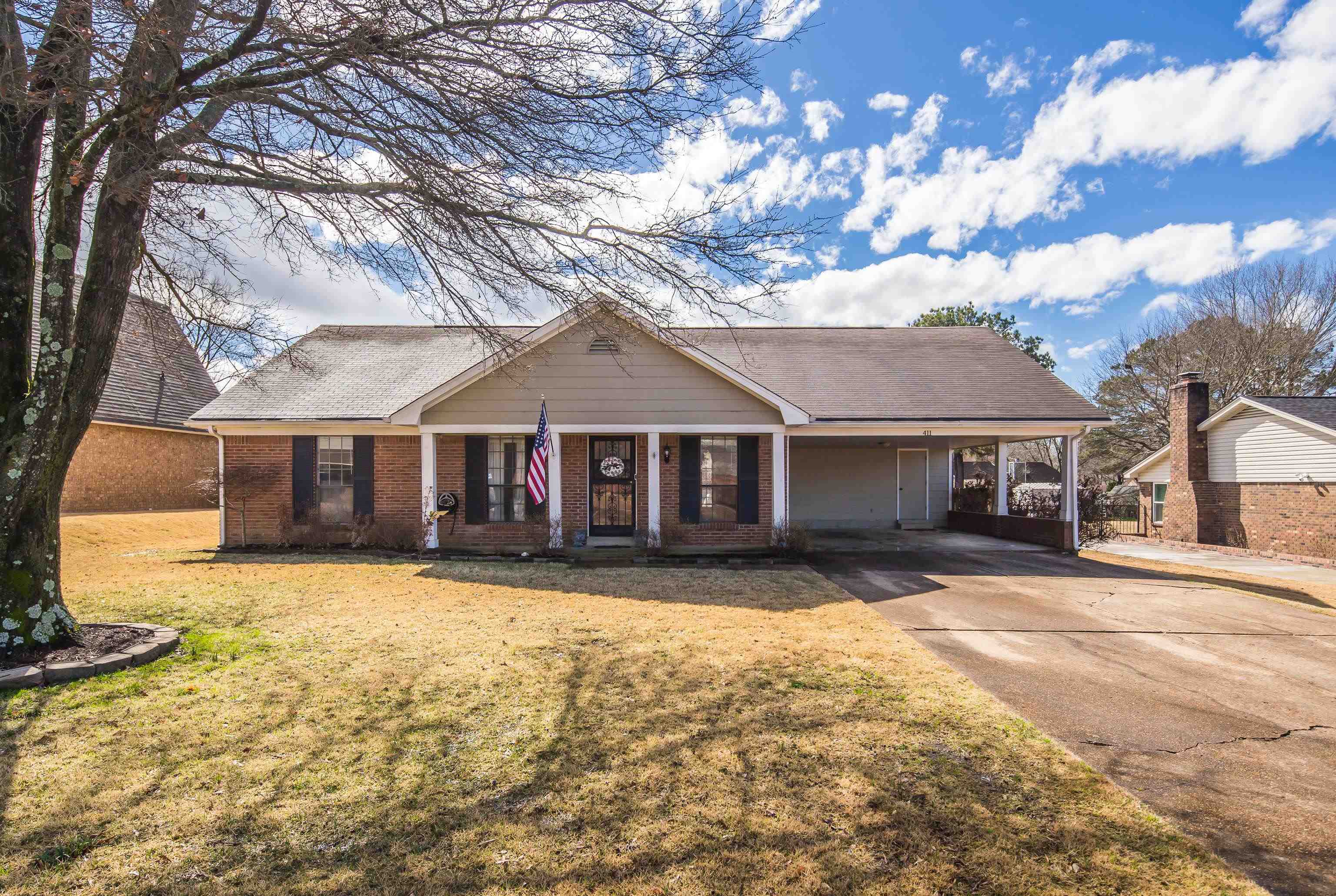 411 Shelton Road Collierville, TN 38017 - Photo 1 of 19 a front view of a house with a yard covered with snow in front of house