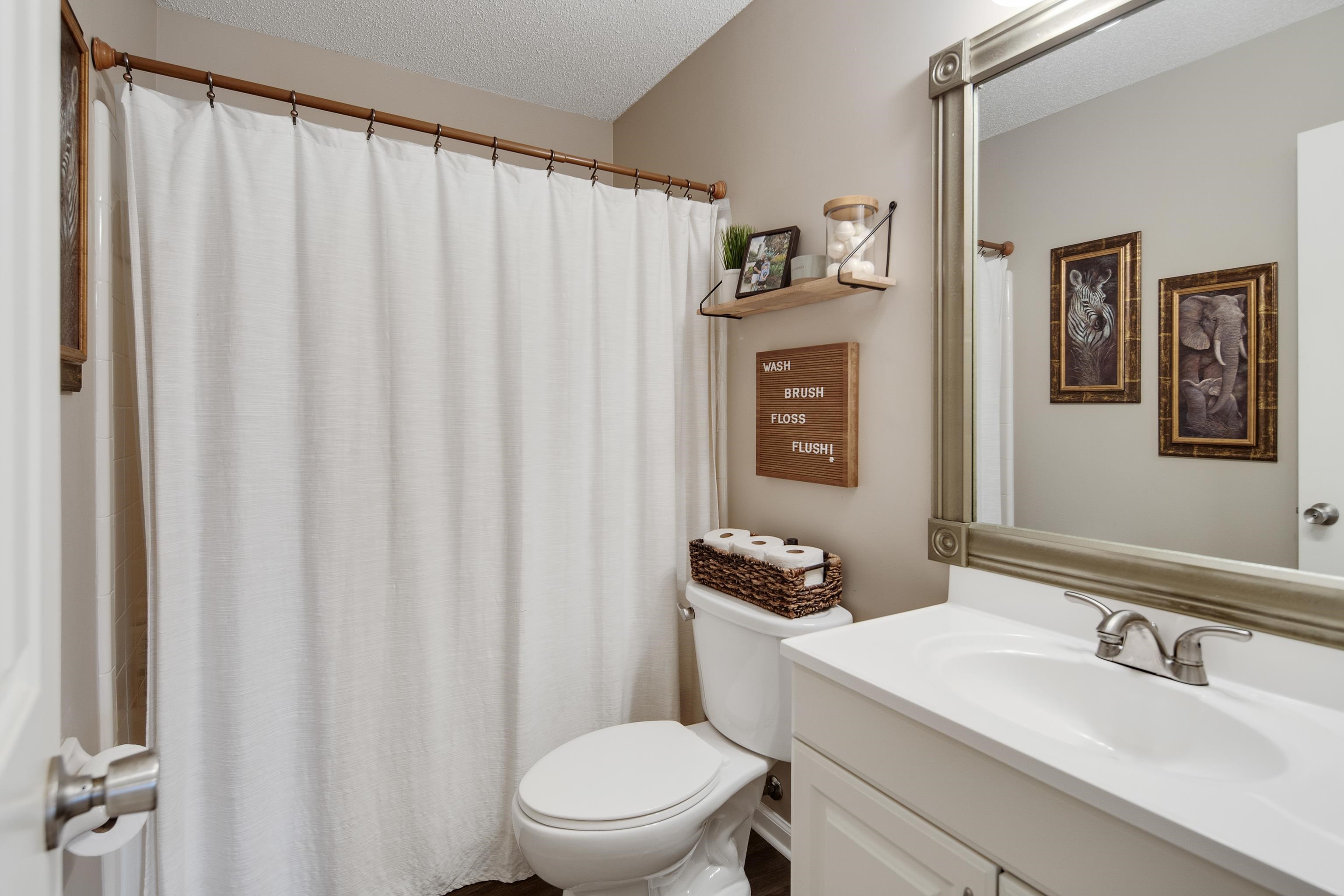 411 Shelton Road Collierville, TN 38017 - Photo 15 of 19 a bathroom with a sink a toilet and shower curtain