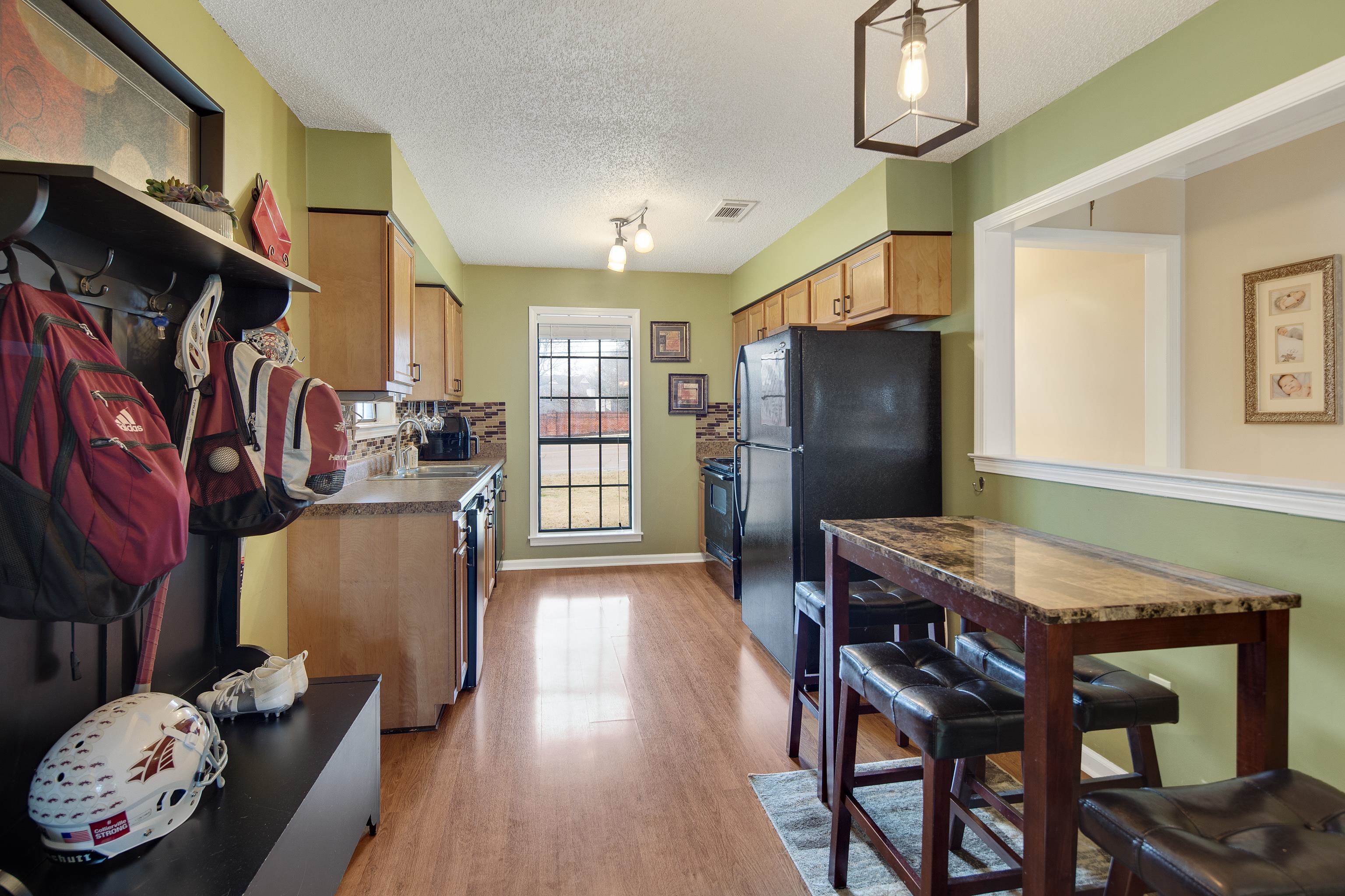 411 Shelton Road Collierville, TN 38017 - Photo 6 of 19 a kitchen with stainless steel appliances granite countertop a dining table chairs refrigerator and sink