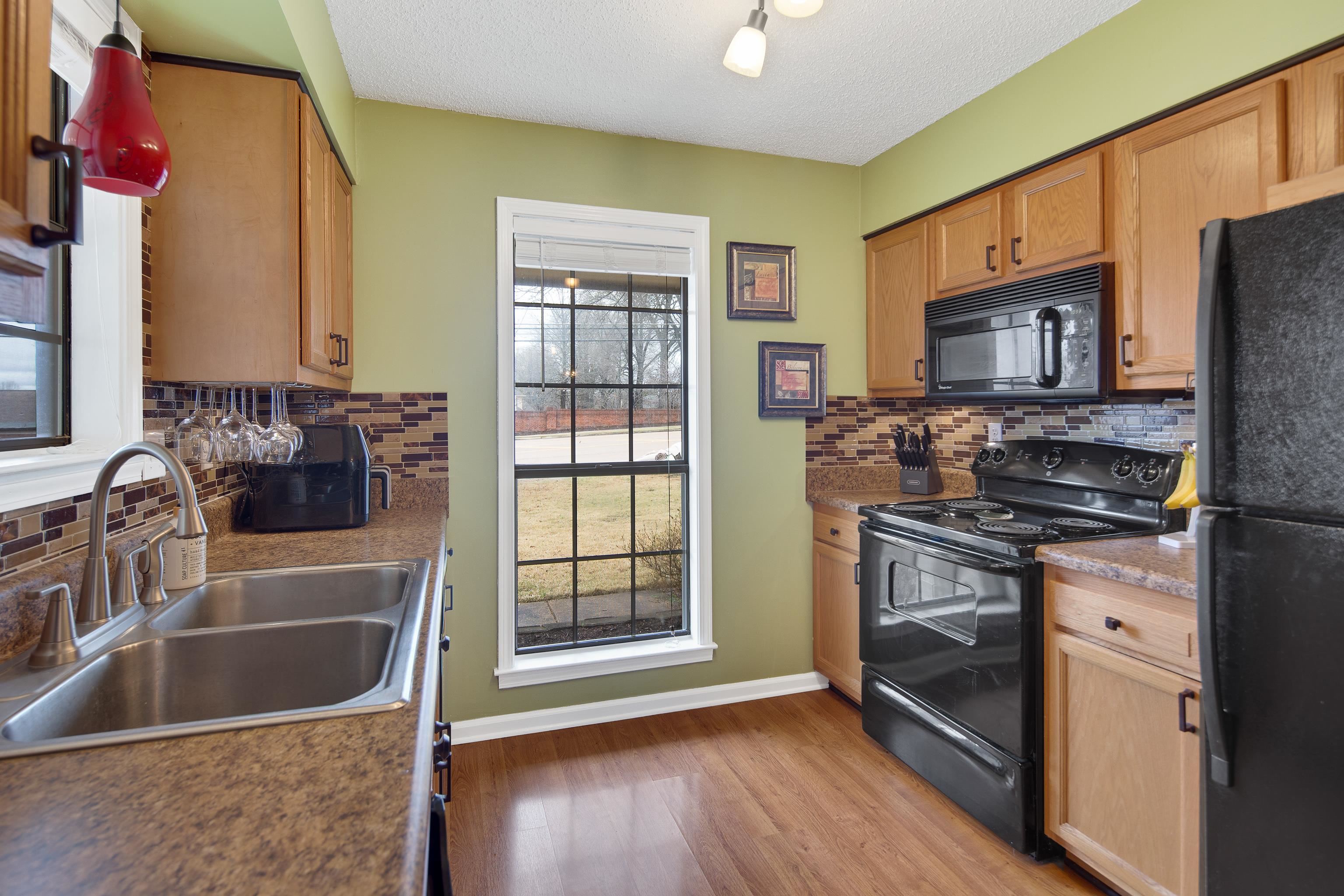411 Shelton Road Collierville, TN 38017 - Photo 8 of 19 a kitchen with granite countertop a sink and a refrigerator