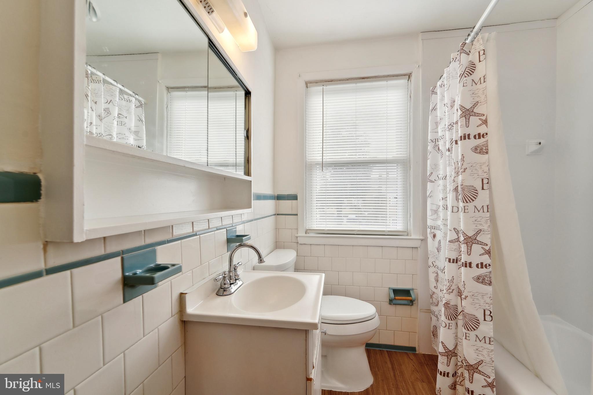 1100 Cedarcroft Road Baltimore, MD 21239 - Photo 16 of 34 a bathroom with a sink a toilet and a mirror
