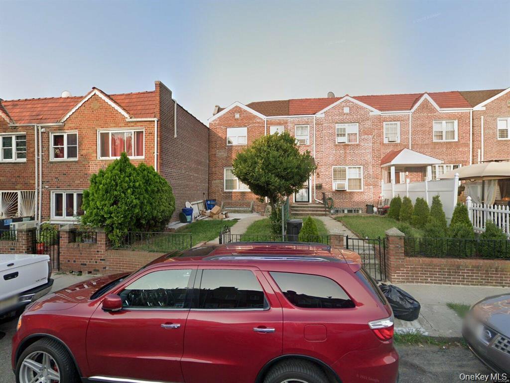 24-12 86th Street, Unit 2 Queens, NY 11369 - Photo 7 of 7 Traditional-style home with a fenced front yard and brick siding