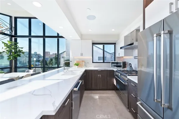 a kitchen with stainless steel appliances granite countertop a refrigerator a sink and a stove