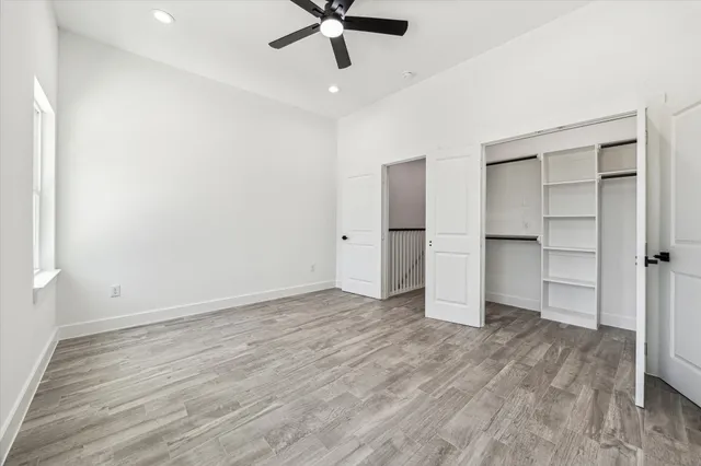 an empty room with closet and windows
