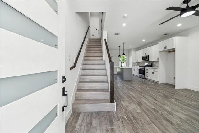 a view of entryway and hall with wooden floor