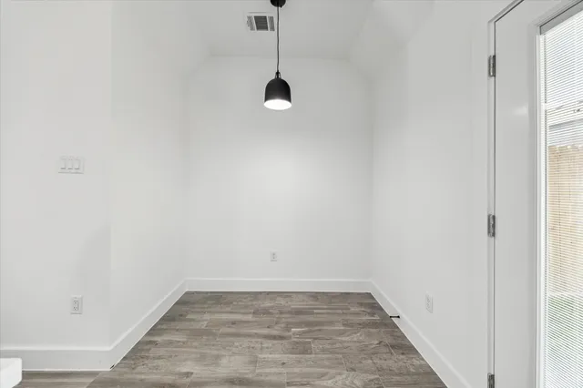 a view of a room with wooden floor and white walls