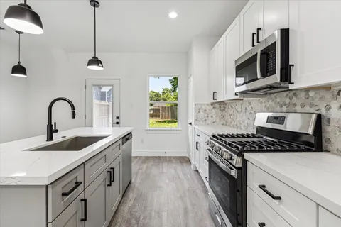 a kitchen with stainless steel appliances a sink stove and microwave