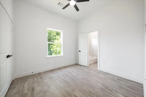 an empty room with a window and a ceiling fan