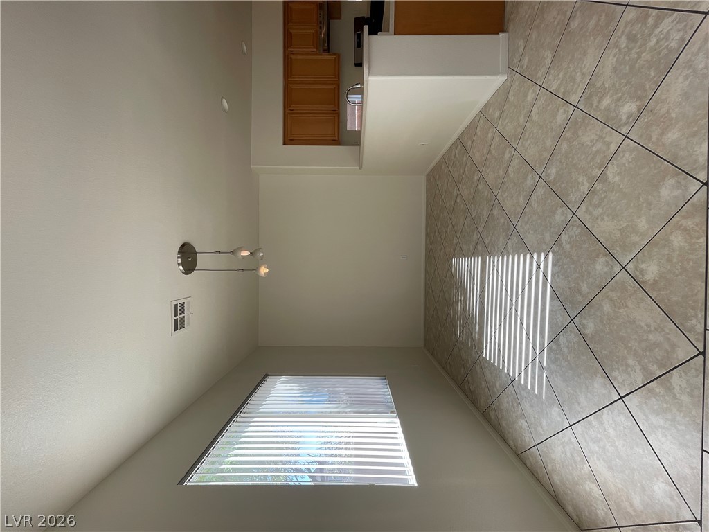 An open dining area flows directly into the kitchen through tiled flooring.