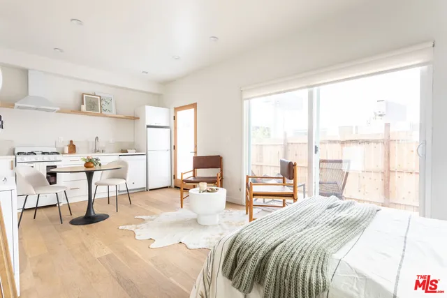 a bedroom with a bed a large window and chair