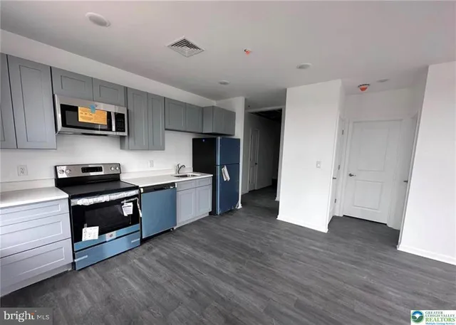 a kitchen with stainless steel appliances a stove a sink and a refrigerator