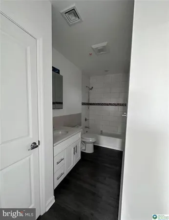 a bathroom with a granite countertop sink a toilet and a shower