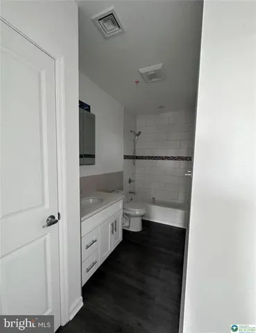 a bathroom with a granite countertop sink a toilet and a shower