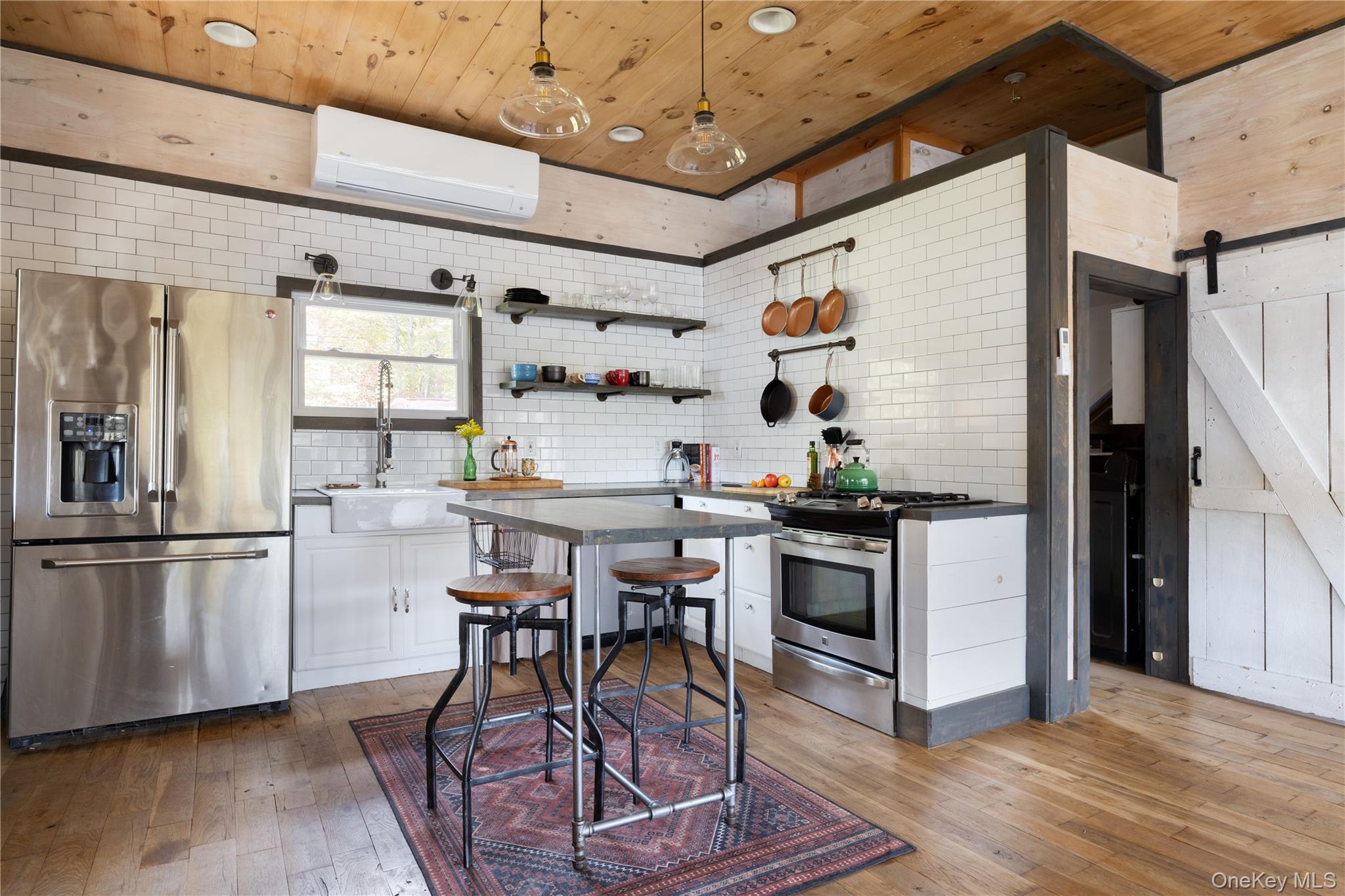 212 Trout Brook Road Roscoe, NY 12776 - Photo 5 of 29 a kitchen with stainless steel appliances granite countertop a table chairs in it and wooden floors