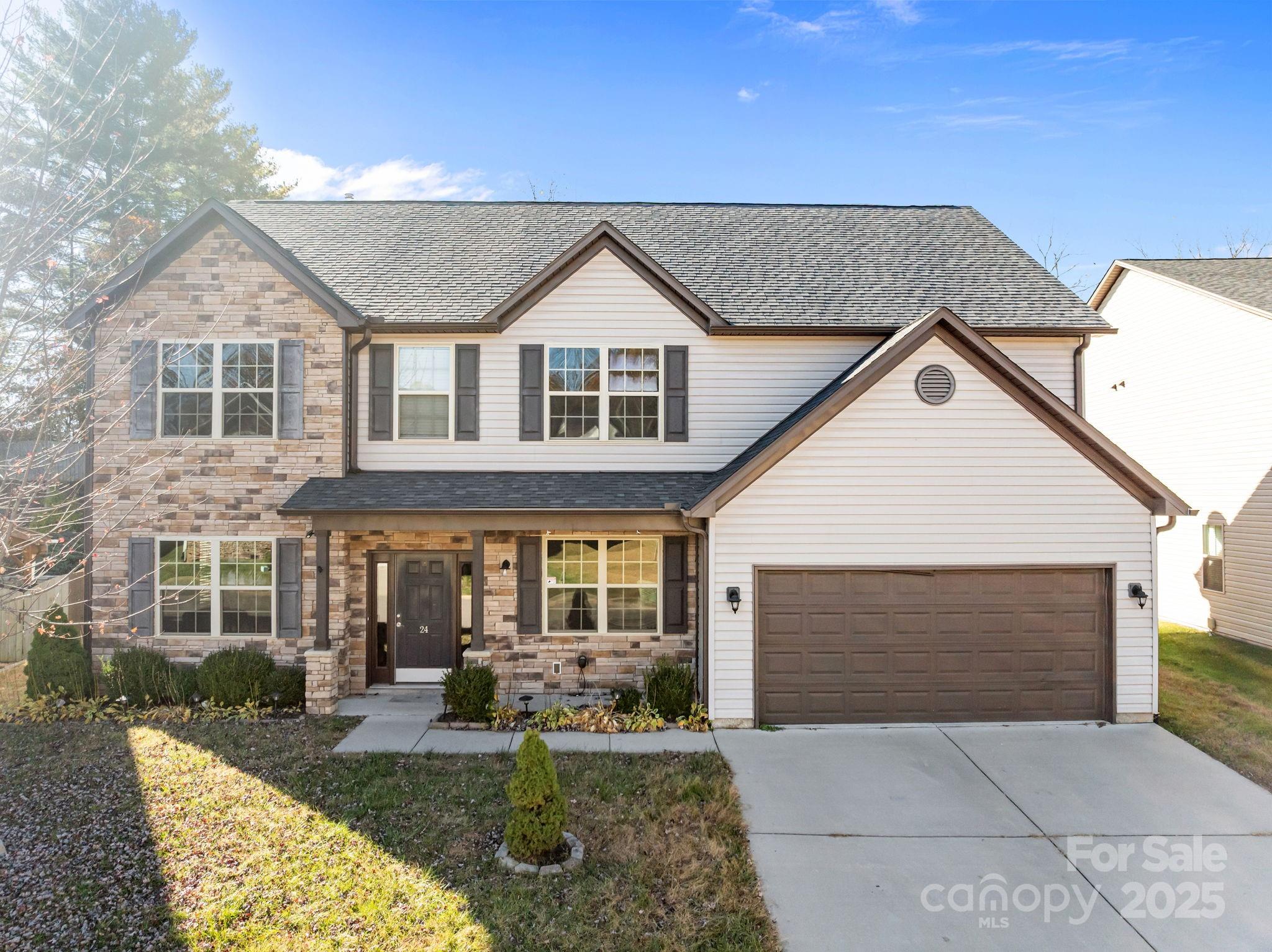 a front view of a house with yard outdoor seating and garage