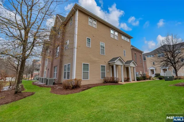 a front view of a house with a garden and trees