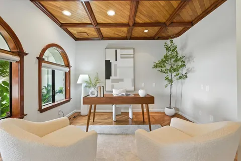 a living room with furniture a large window and a chandelier