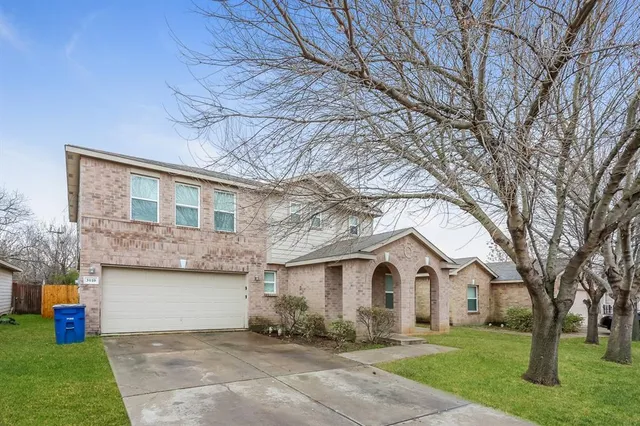 a front view of a house with a yard and trees