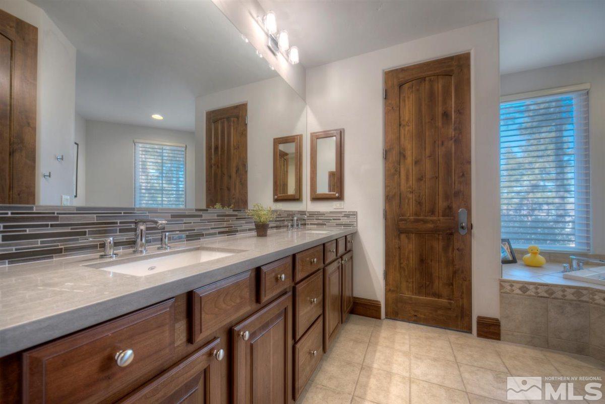 6090 Lake Geneva Drive Reno, NV 89511 - Photo 28 of 40 a bathroom with a sink a vanity and a mirror