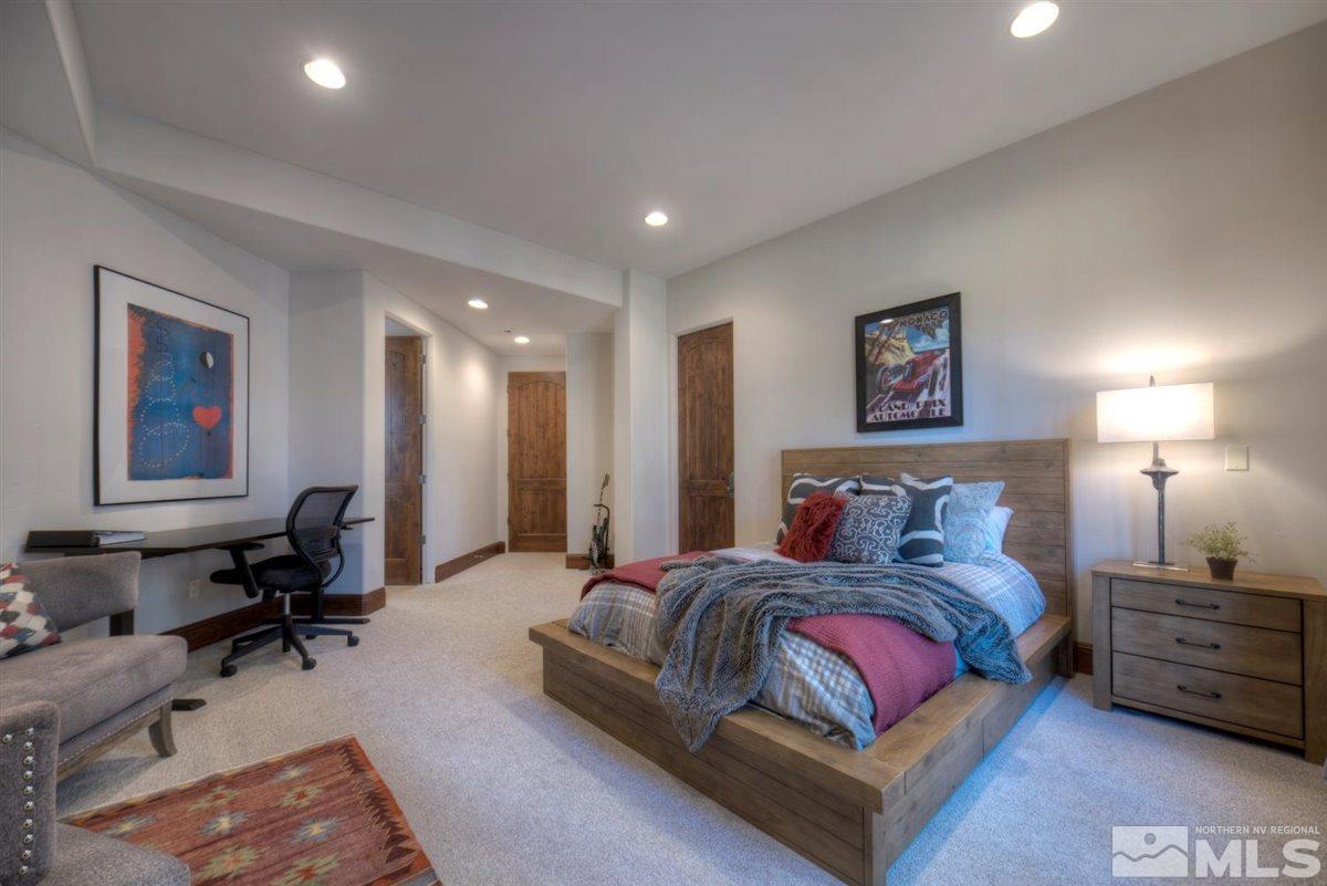 6090 Lake Geneva Drive Reno, NV 89511 - Photo 29 of 40 a spacious bedroom with a bed a table and painting on the wall