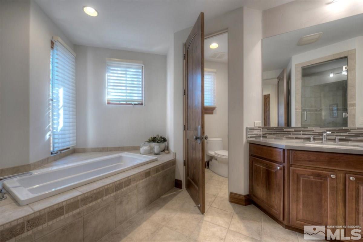 6090 Lake Geneva Drive Reno, NV 89511 - Photo 30 of 40 a bathroom with a tub sink and mirror