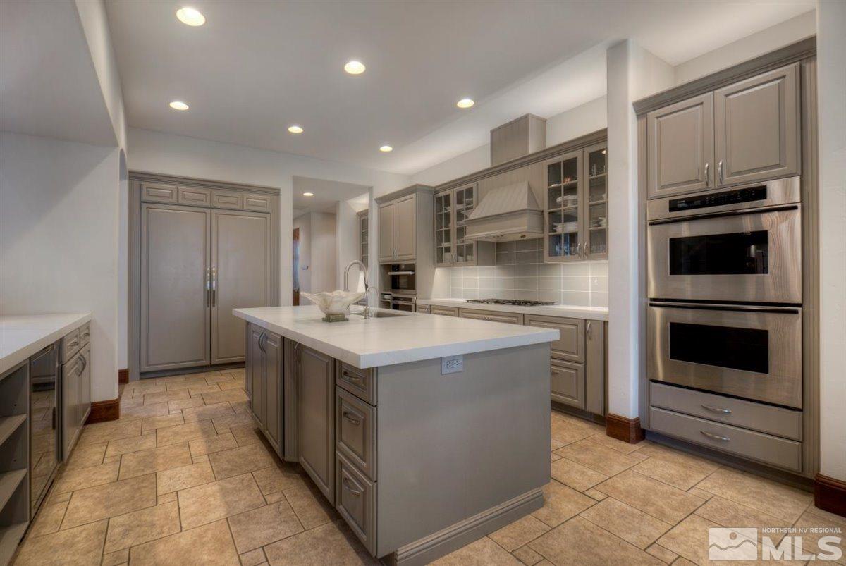 6090 Lake Geneva Drive Reno, NV 89511 - Photo 10 of 40 a kitchen with stainless steel appliances granite countertop a stove and a refrigerator