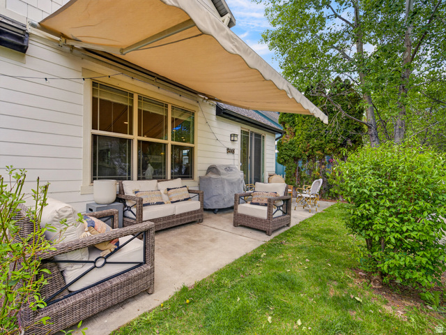 557 Craftsman Way Midway, UT 84049 - Photo 46 of 59 Outdoor patio featuring a retractable awning, concrete flooring, and direct access to a grassy yard