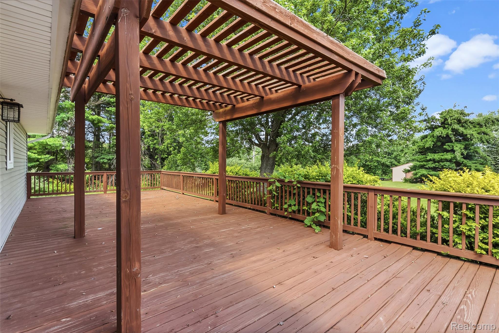 9200 Hickory Ridge Road Holly, MI 48442 - Photo 29 of 33 Spacious exterior deck featuring a rich brown finish, a slatted pergola, and a coordinating wood railing