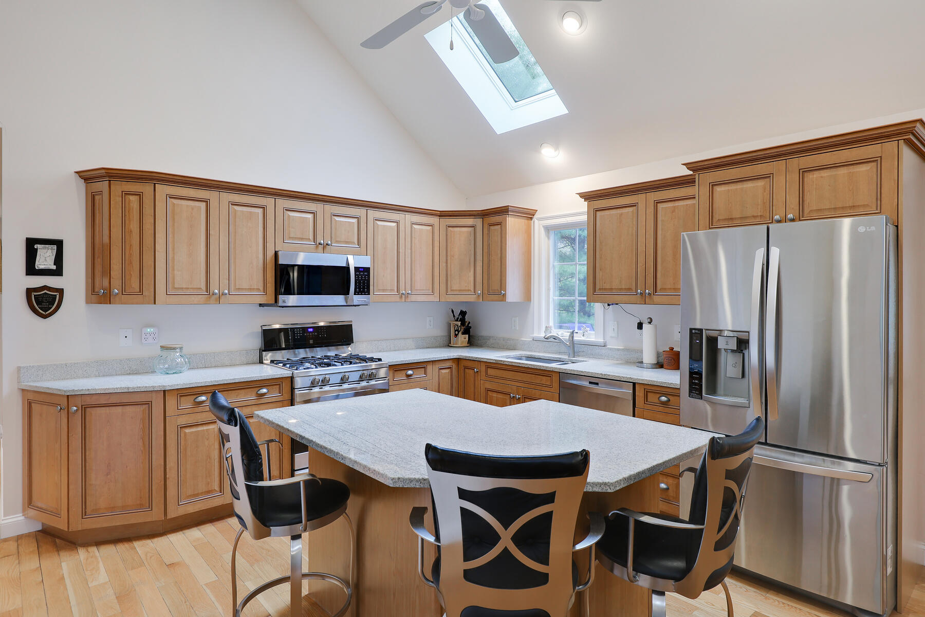 24 Sea Robin Road Osterville, MA 02655 - Photo 8 of 45 a kitchen with stainless steel appliances granite countertop a dining table chairs refrigerator and microwave